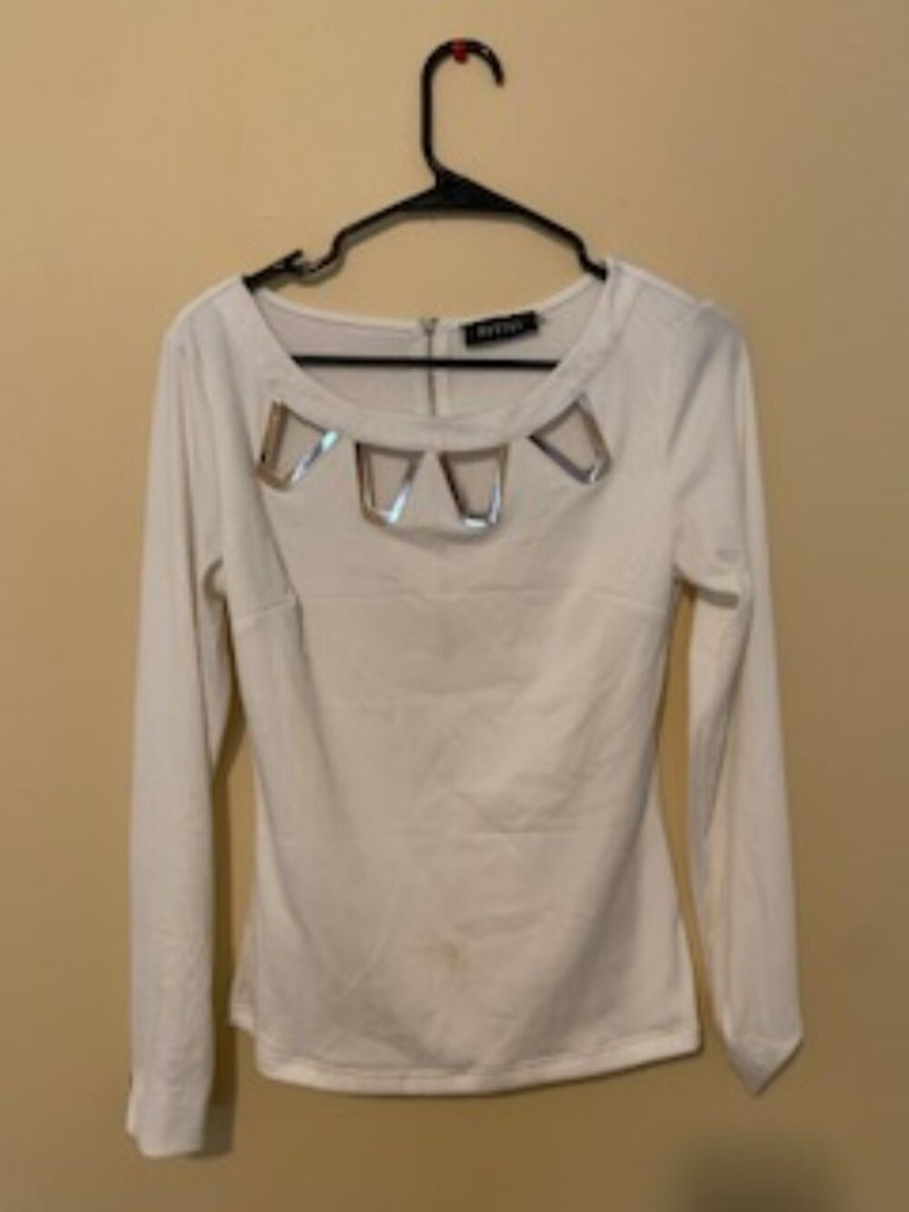 Pastel white top with gold/metal embellishing on top and arms. Size L